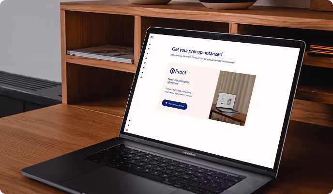 Laptop on a wooden desk displaying a webpage titled 'Get your prenup notarized' from Proof for sending prenup appointment details.