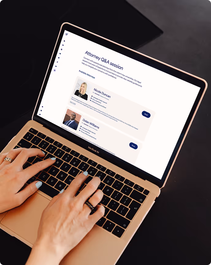 Hands typing on a gold MacBook Air displaying a legal Q&A session webpage with profiles of two attorneys.