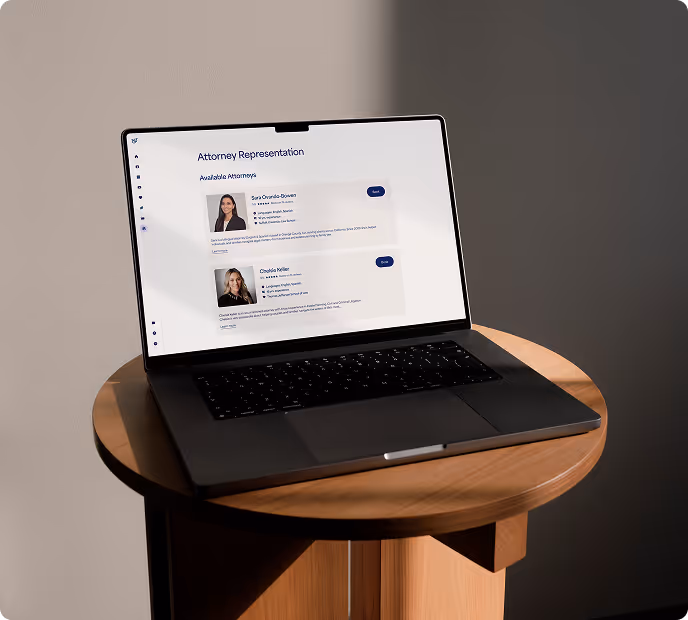 Laptop on round wooden table displaying a webpage titled 'Attorney Representation' with profiles of two attorneys.