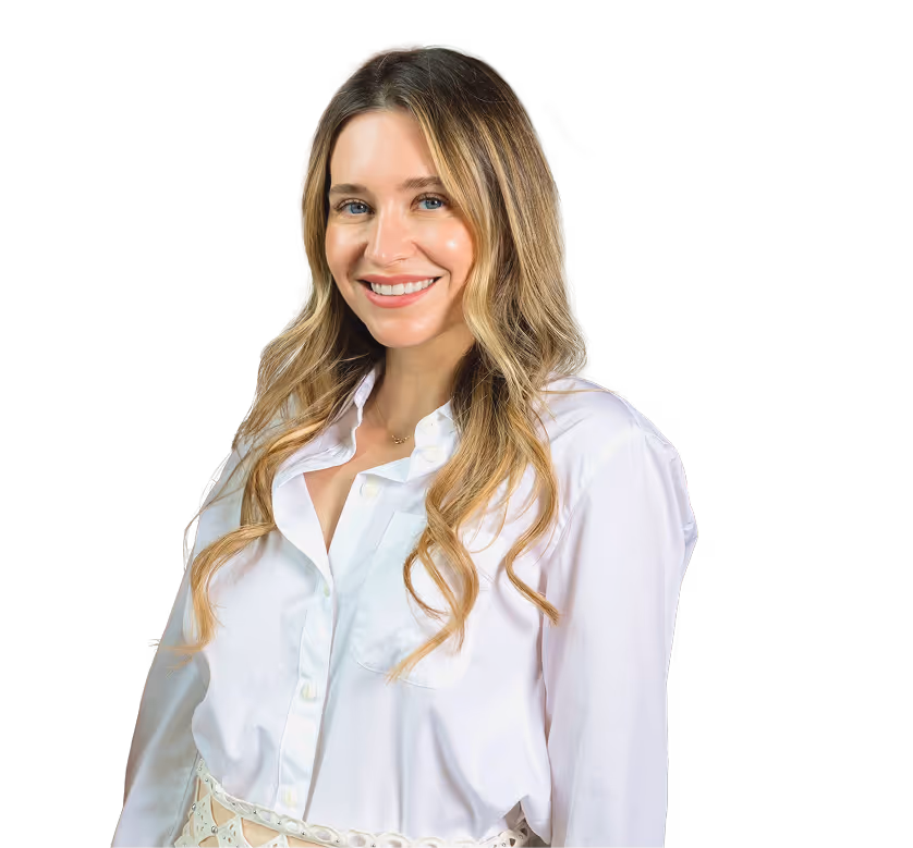 Smiling woman with long wavy blonde hair wearing a white button-up shirt.