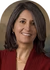 Smiling woman with shoulder-length brown hair wearing a red top.