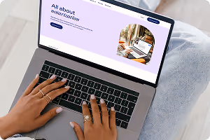 Person typing on a laptop displaying a website with the heading 'All about motivation'.