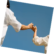 Two people holding hands against a clear blue sky.