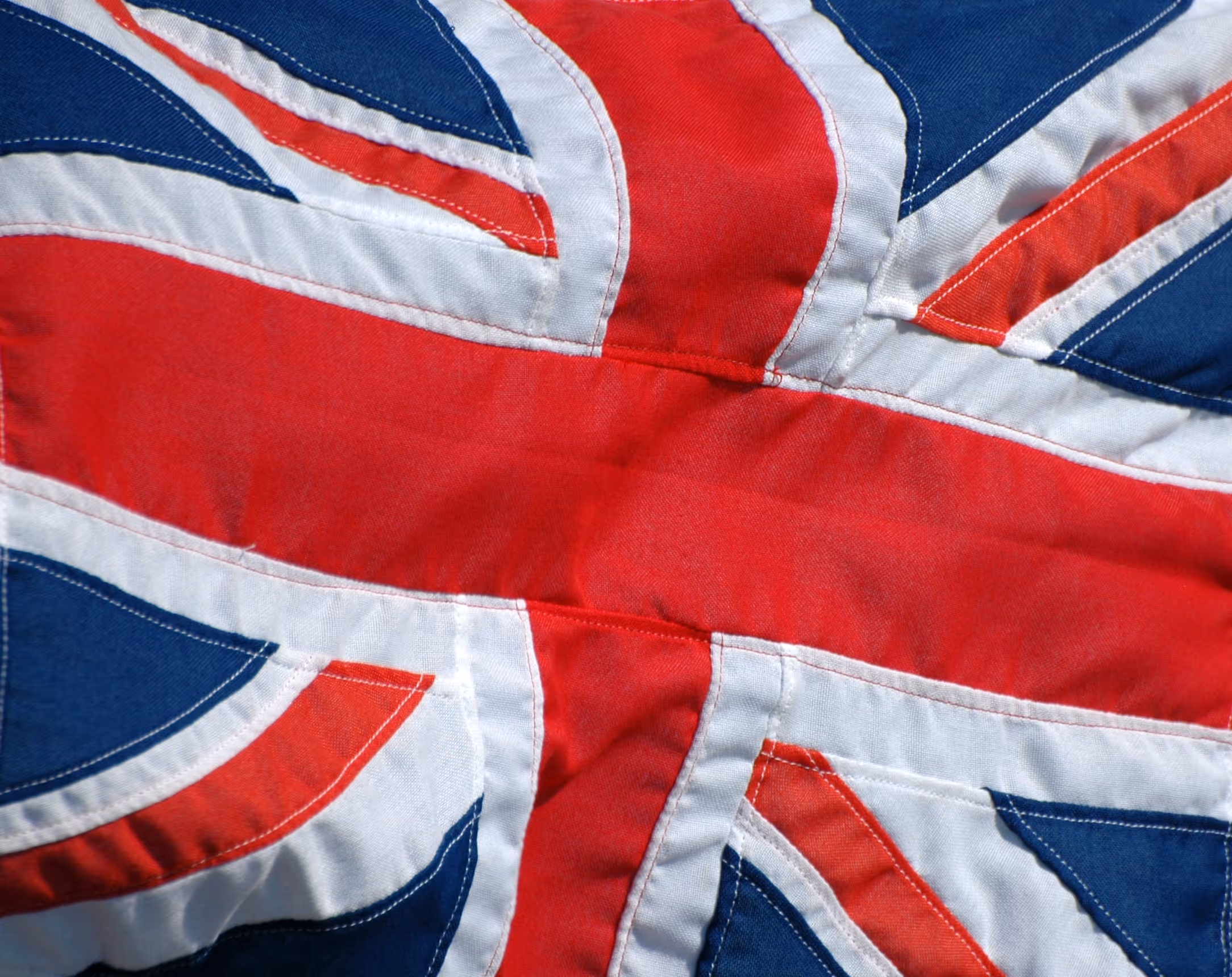 Close-up of a wrinkled British Union Jack flag showing red, white, and blue colors.