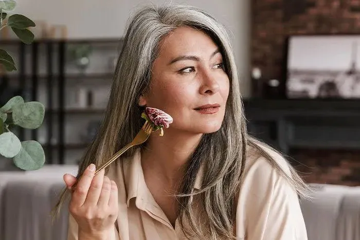 Headshot of woman eating a healthy meal.