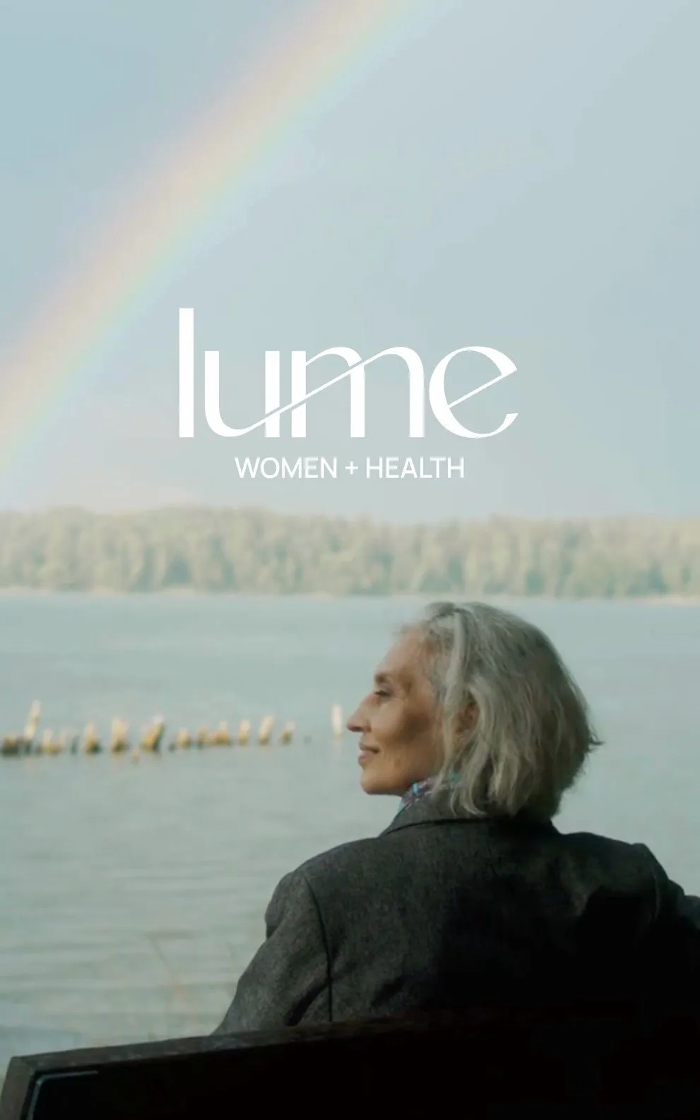 Woman sitting by the lake enjoying a rainbow view.