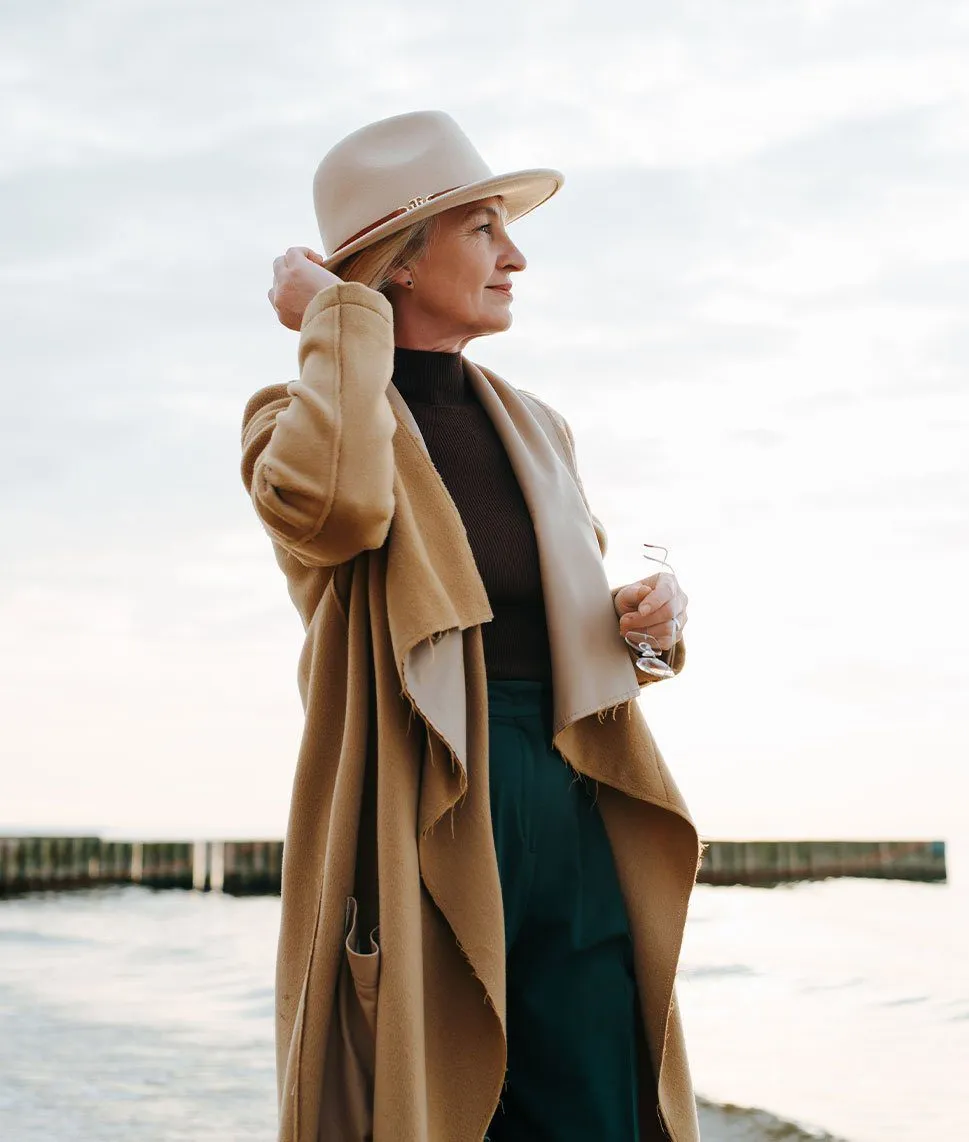 Well dressed woman standing by the pier.