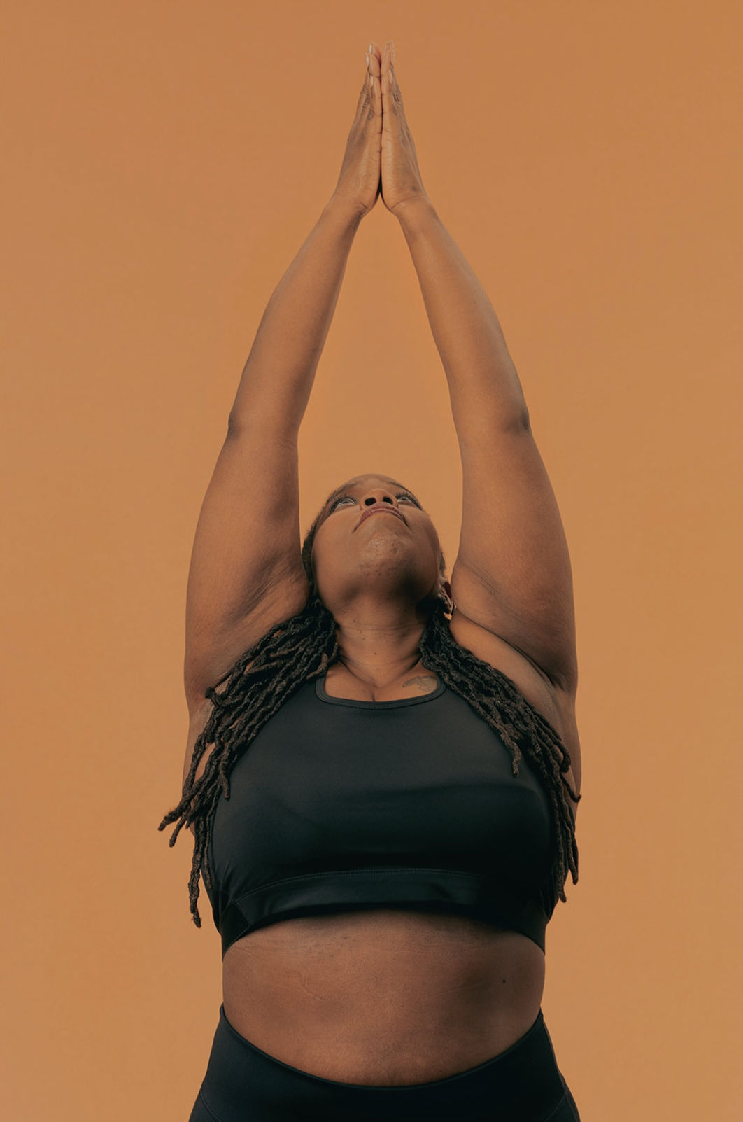 Women with arms outstretched above her head.