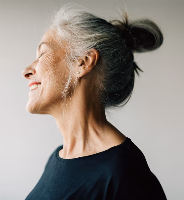 woman standing by the window enjoying sunlight