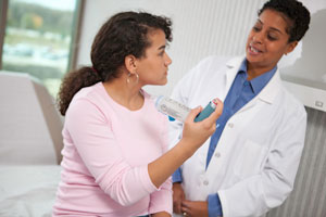 Health care provider showing person how to use inhaler with spacer.