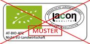 Logo eines grünen Quadrats mit weißen Sternen und dem Text 'AT-BIO-402 NICHT-EU Landwirtschaft' sowie einem roten diagonalen Kreuz und dem Schriftzug 'MUSTER'.