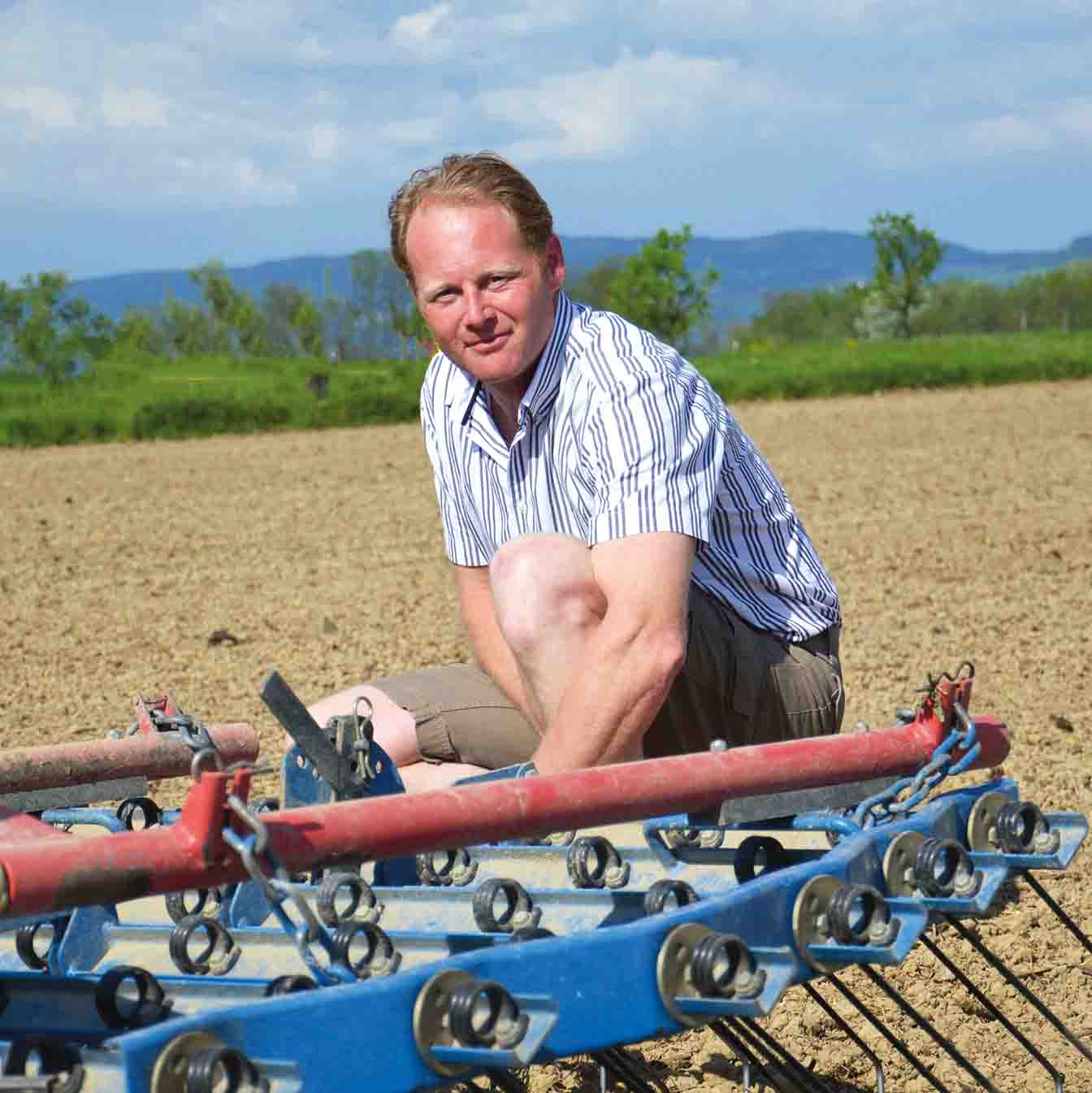 Ein Mann kniet auf einem Feld