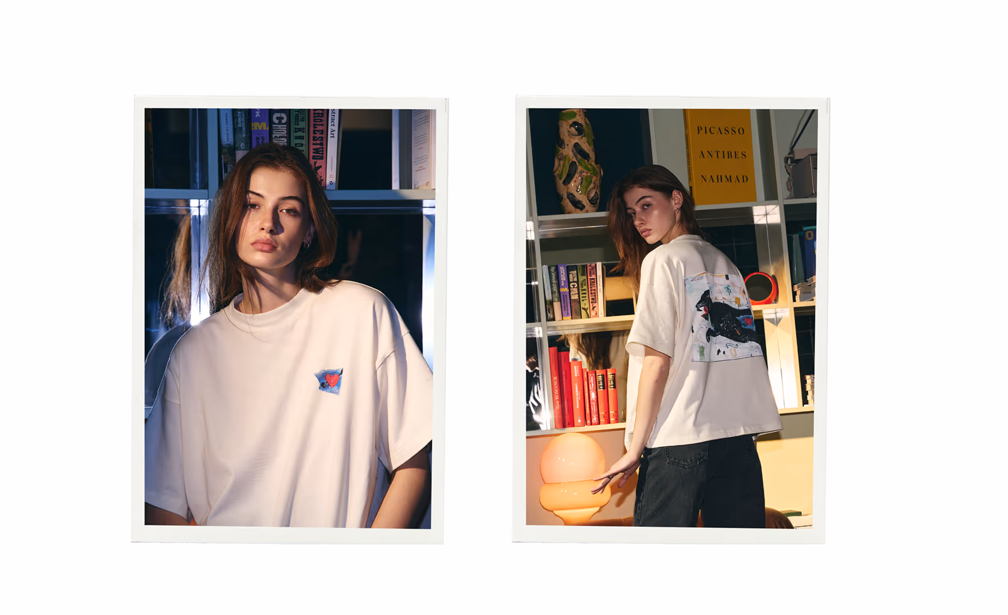 Young woman wearing a white oversized T-shirt with a small heart design on the front and a large abstract black cat design on the back, standing in a room with bookshelves and a lamp.