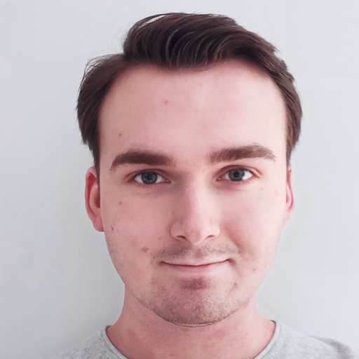 Headshot of a young man with brown hair and blue eyes wearing a light gray shirt, looking straight at the camera with a neutral expression.