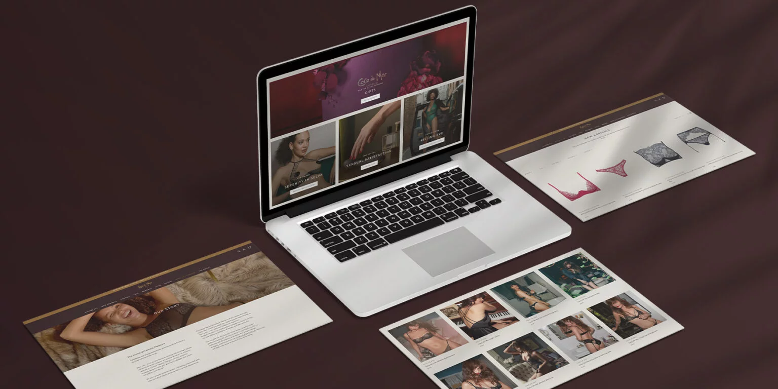 Open laptop displaying a lingerie website surrounded by multiple printed web pages featuring lingerie products and models on a dark surface.