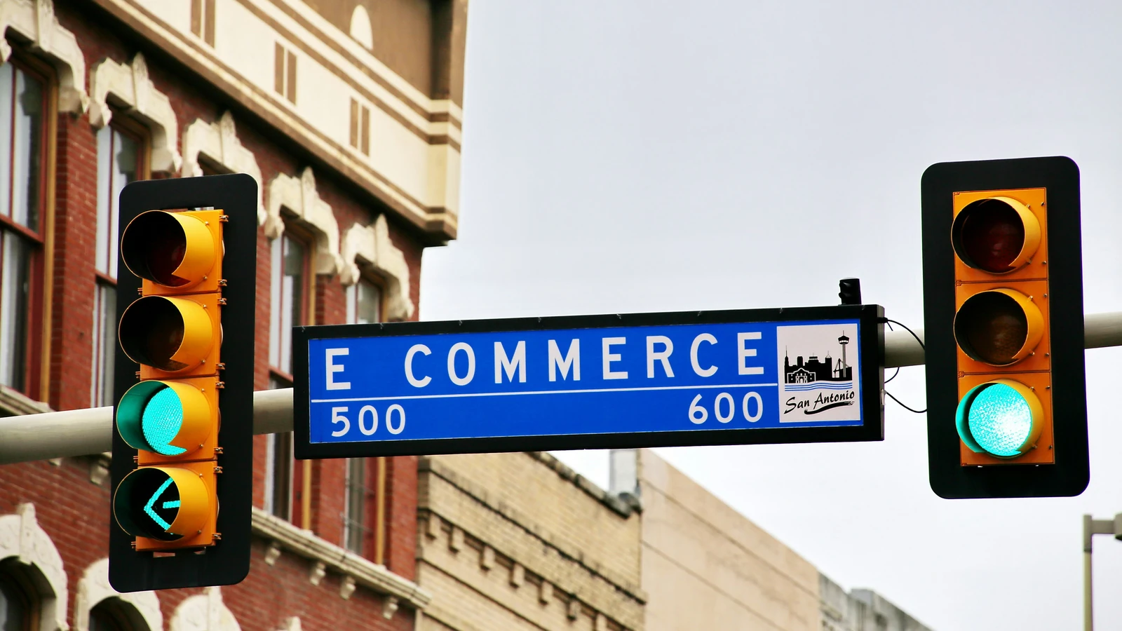 Blue 'E Commerce' street sign between two traffic lights showing green, symbolising the move to Shopify Plus B2B