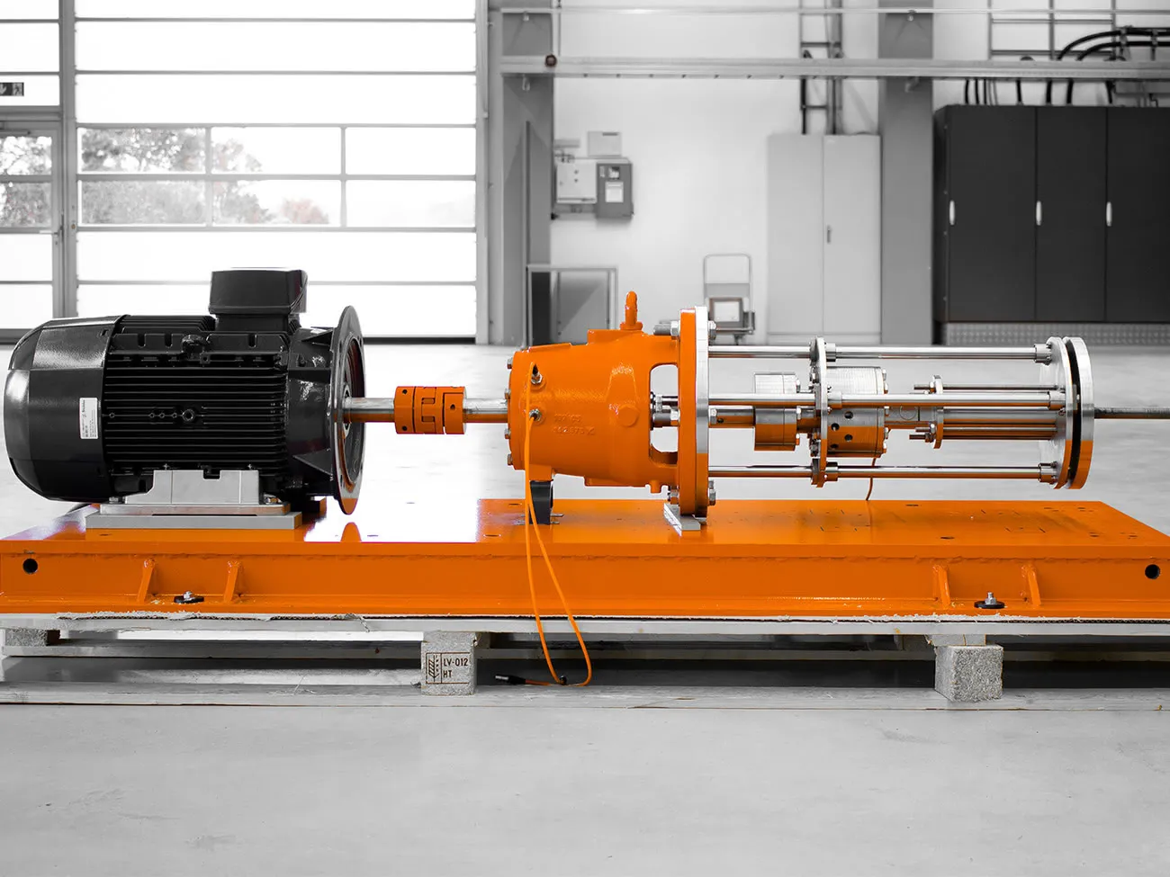 Bild: Motor und Lagerträger einer Pumpe mit angeflanschtem Kalibriermodul auf Grundplatte zur Kalibrierung