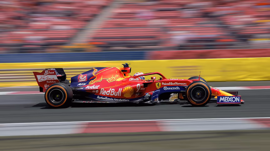 A Red Bull racing car moving fast. 