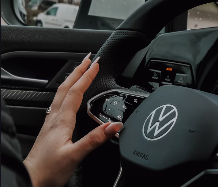 Hand am Lenkrad eines VW Firmenwagens