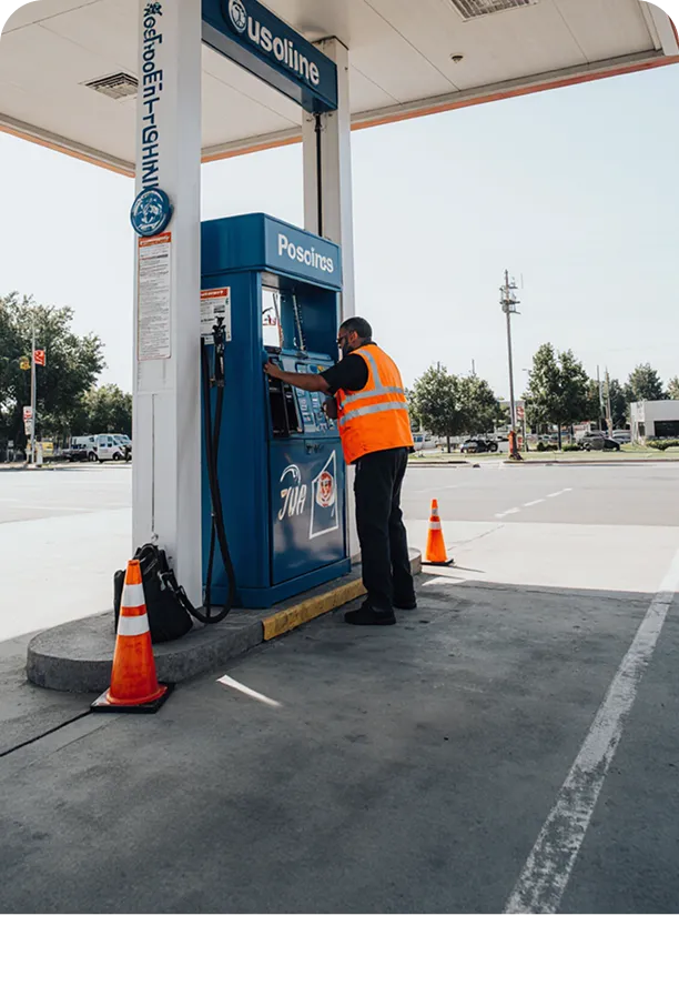 Worker in vest at fuel pump.