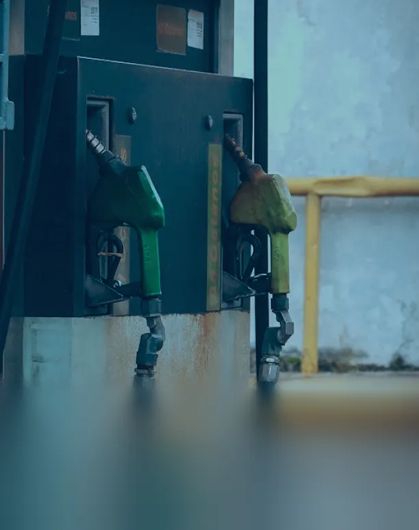 Two old fuel nozzles on rusty pump.