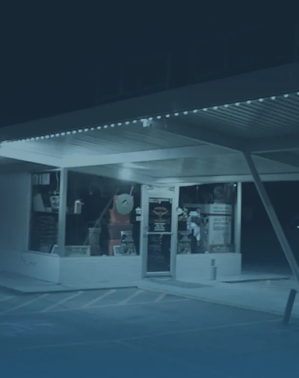 Small lit shop with glass windows at night.