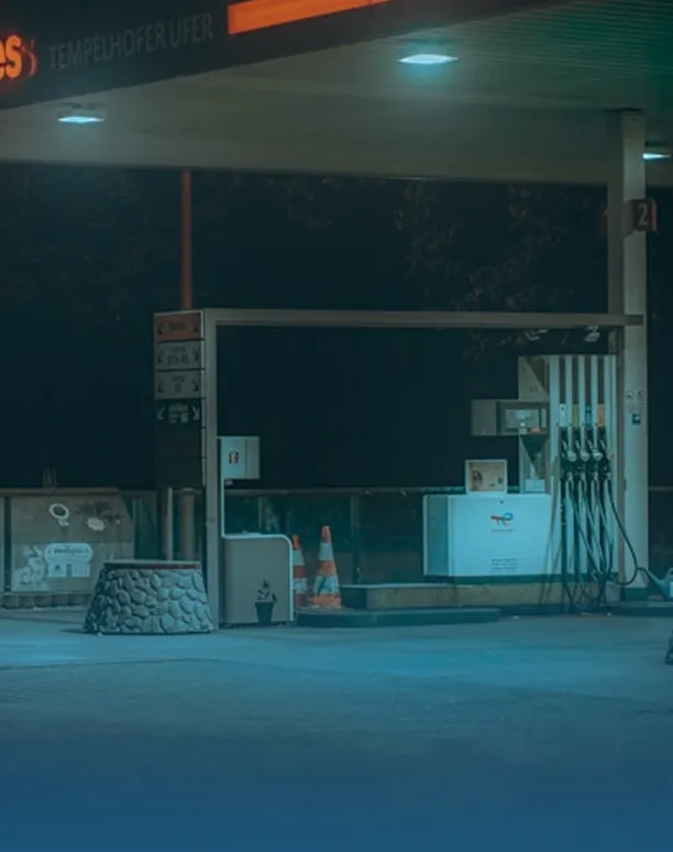 Empty gas station with orange signage.