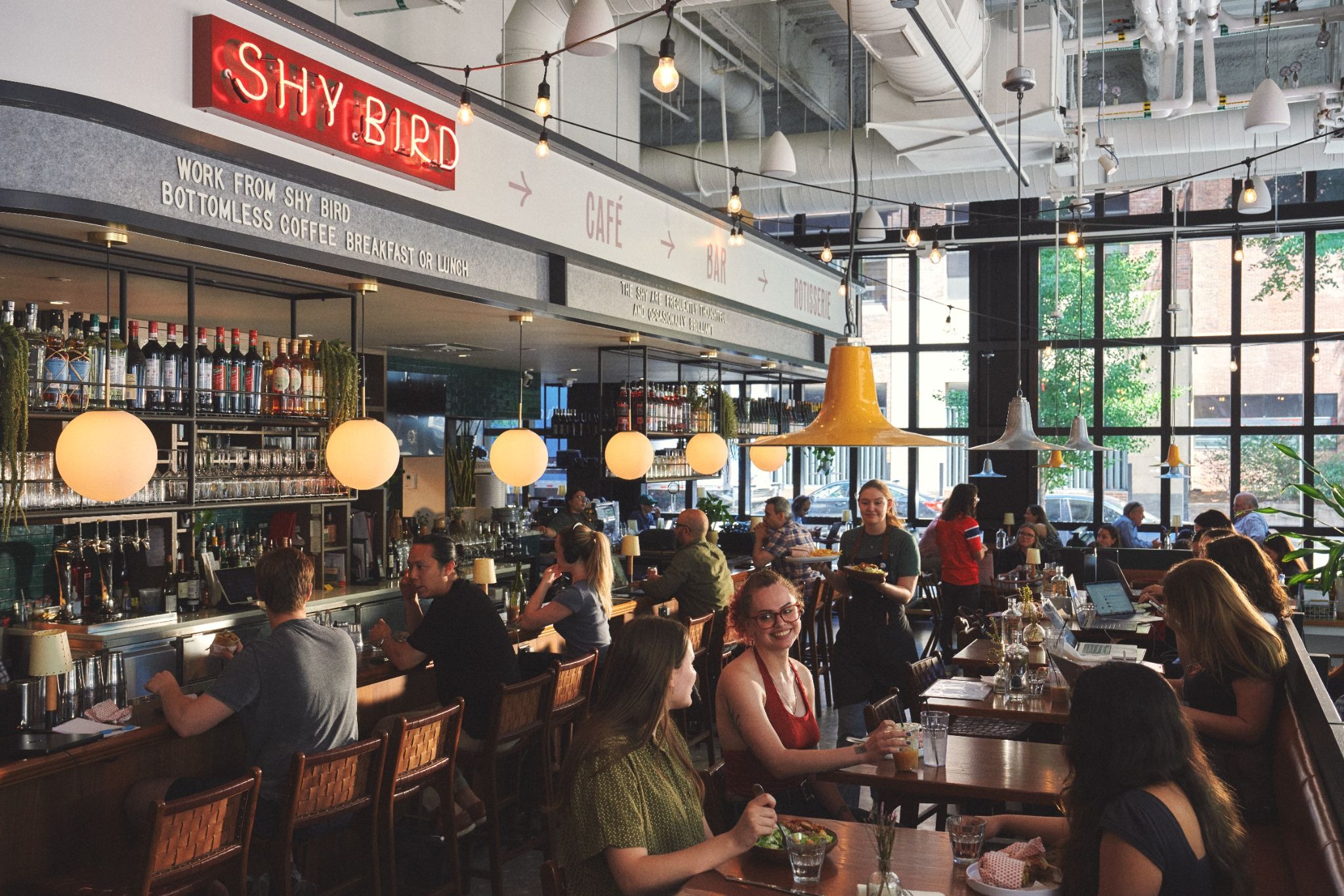 The dining room and bar of Shy Bird, full of diners for Brunch