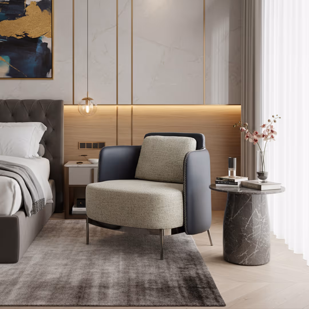 Contemporary hotel bedroom with 1902 Evo accent armchair, marble side table, tufted bed, and ambient lighting