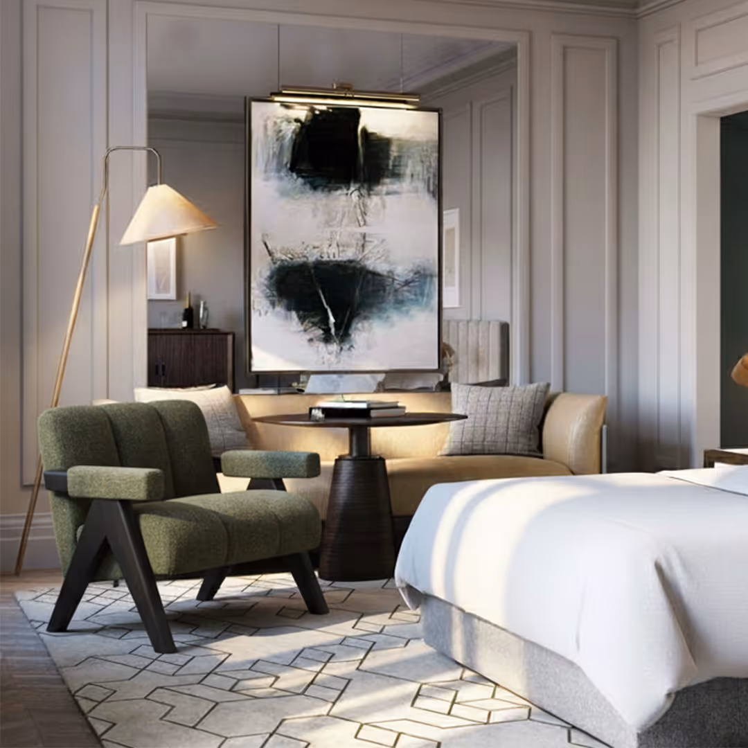 Sophisticated hotel bedroom with 1902 Sloane green armchair, beige loveseat, abstract artwork, and geometric rug under warm lighting