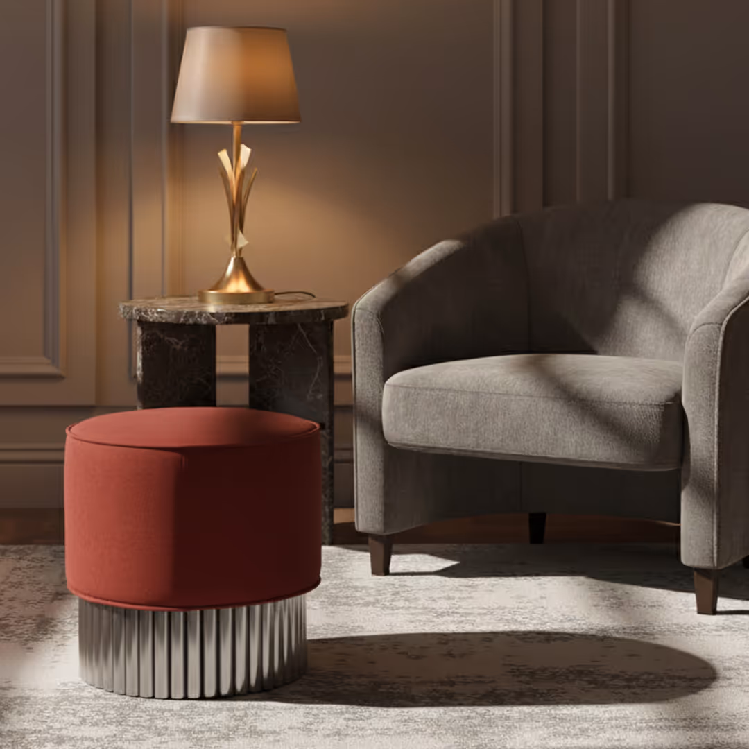 Stylish guestroom interior with 1902 Fika red ottoman, sculptural gold lamp, gray armchair, and dark marble side table on textured rug