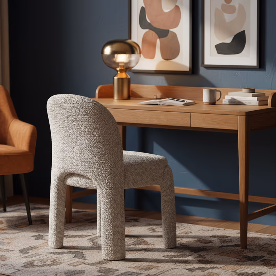 Luxury hotel room with 1902 Riva boucle desk chair, wood desk, brass lamp, abstract artwork, and orange accent armchair