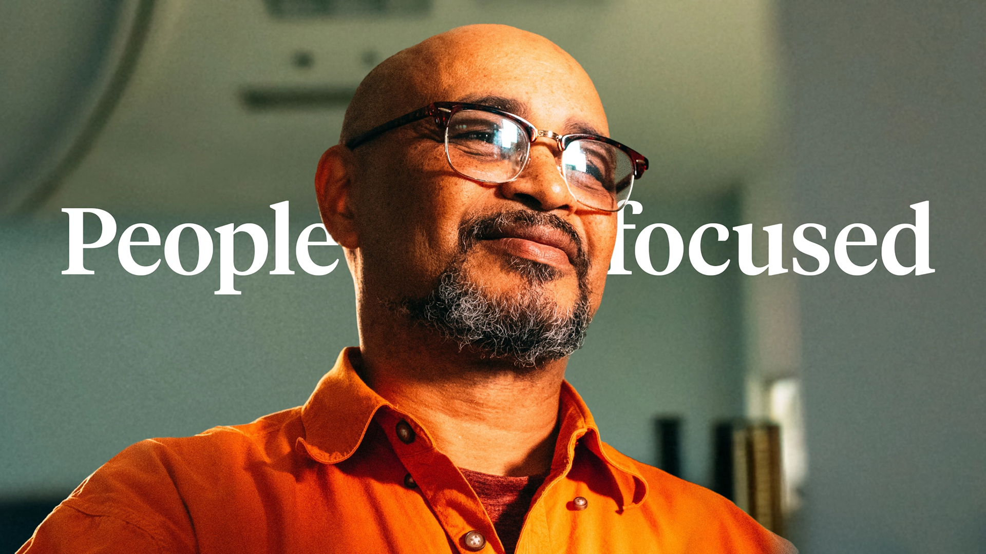 Laptop and smartphone on an orange fabric chair displaying the Minerva website, with pages on diversity and services.