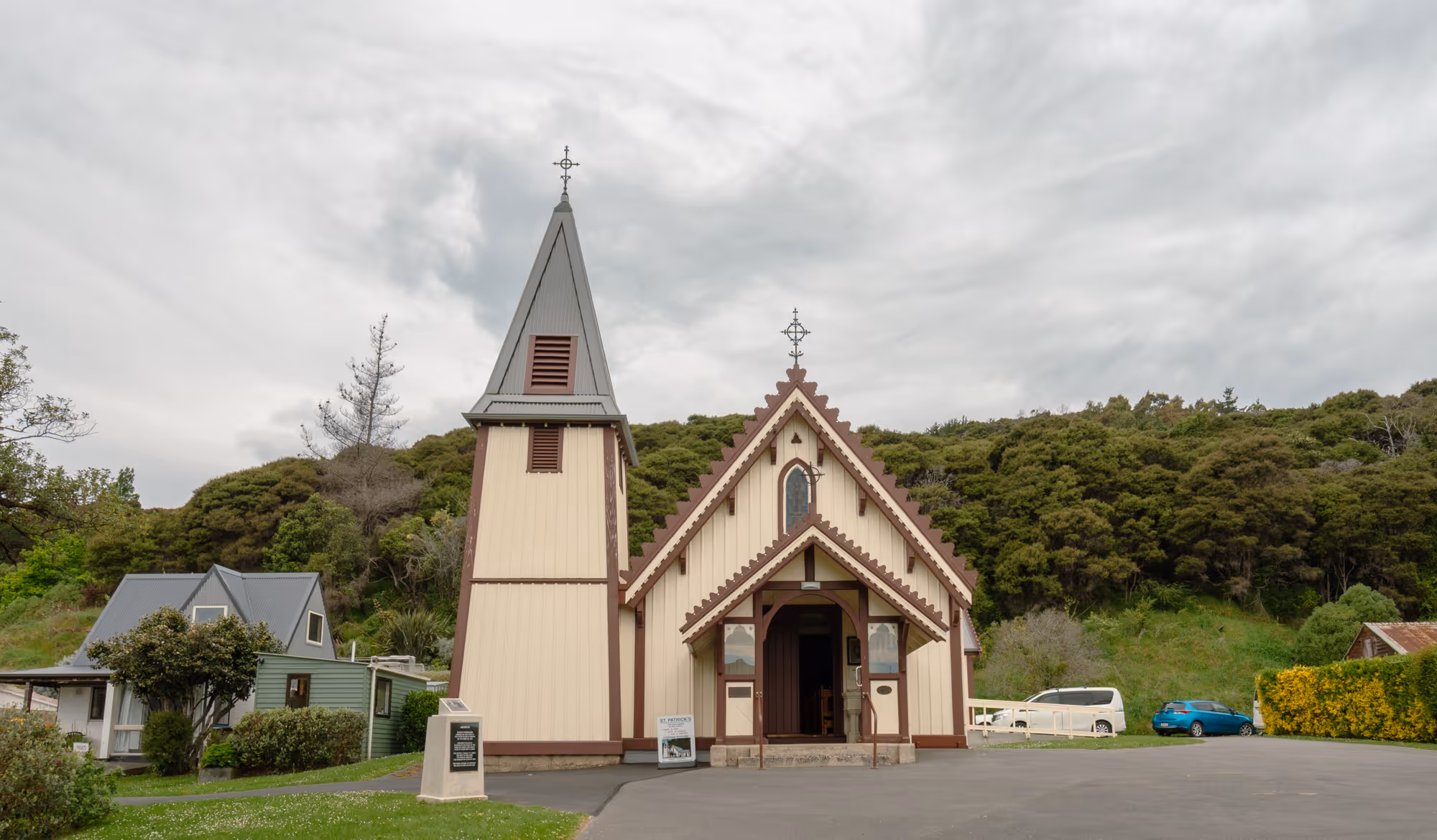 Outside of St Patrick Church in Akaroa with bush around it
