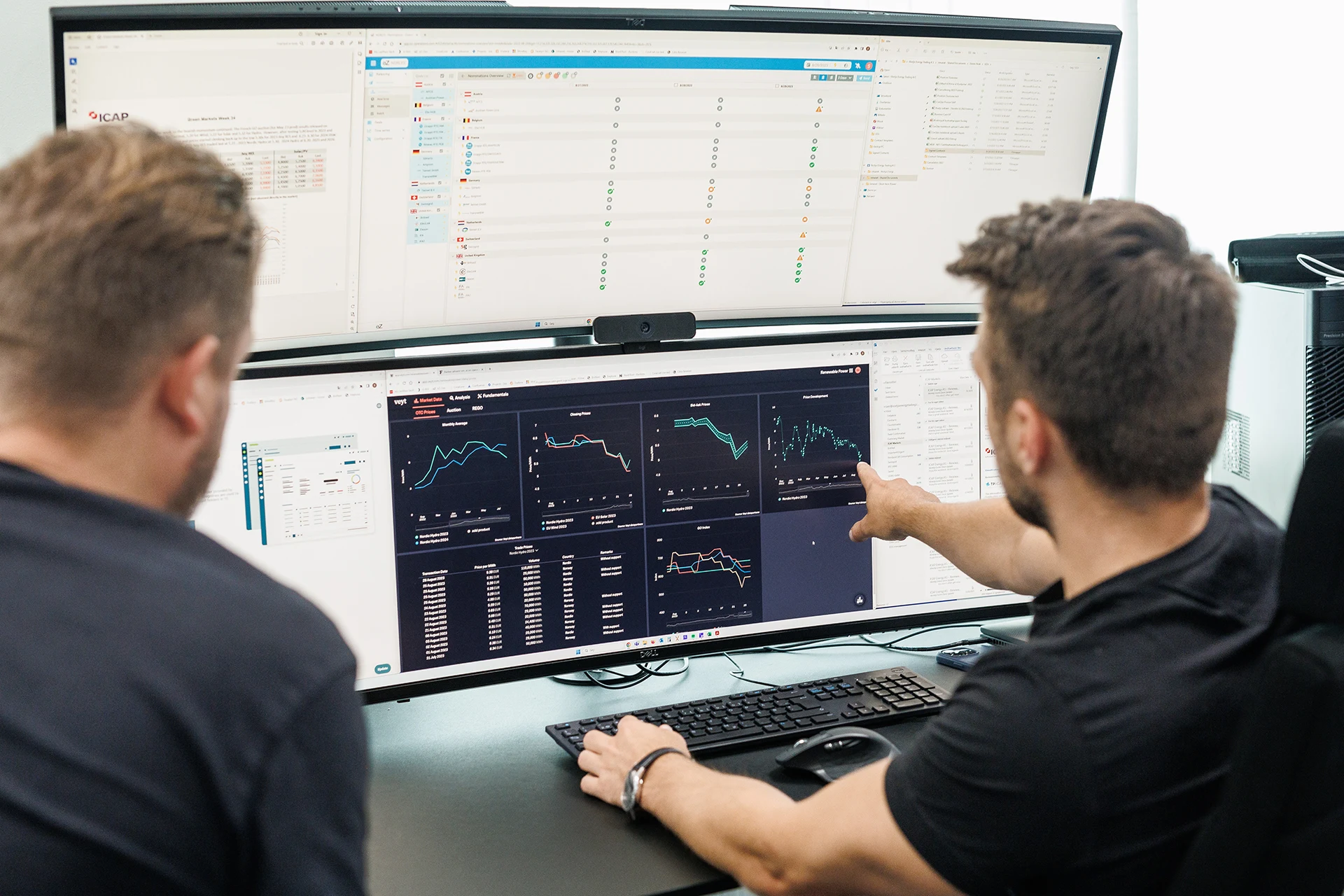 Two men are looking at a computer screen.