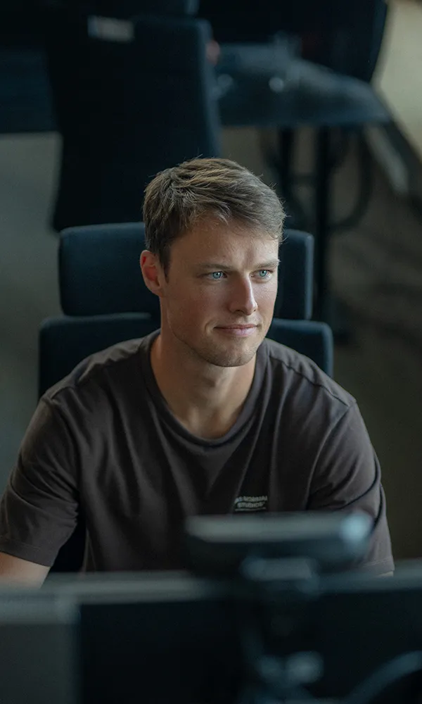 A man sitting at a desk looking at a computer