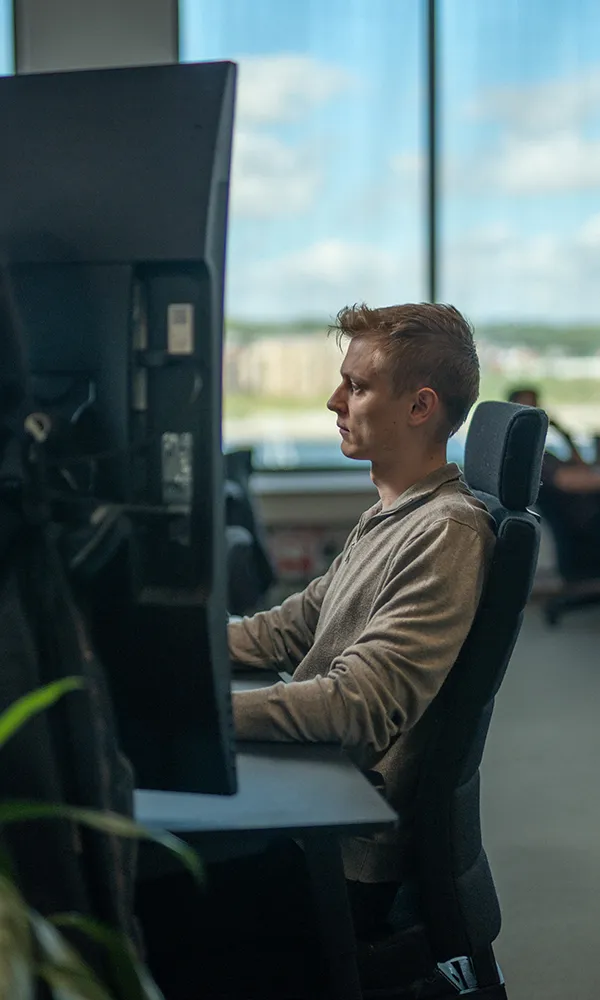 A man sitting at a desk looking at a computer screen