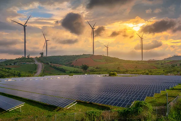 A field with solar panels and wind mills