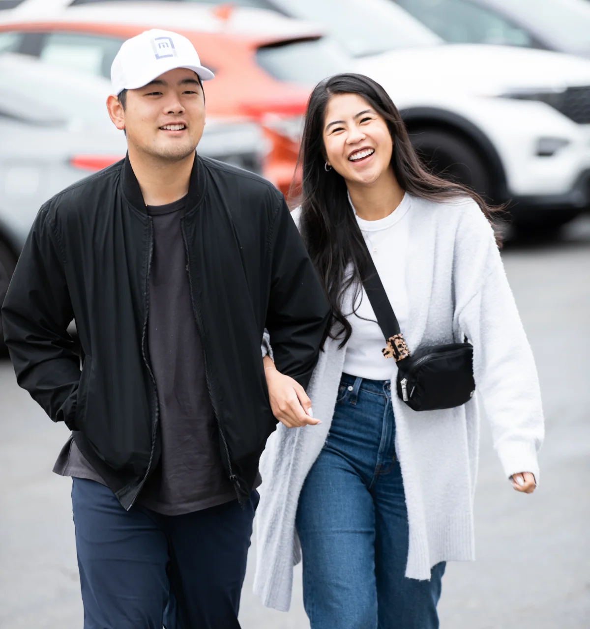 Young couple walking outdoors smiling and laughing together.