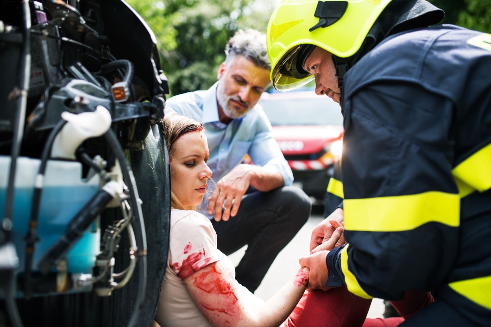 First responder providing emergency care to injured woman at accident scene