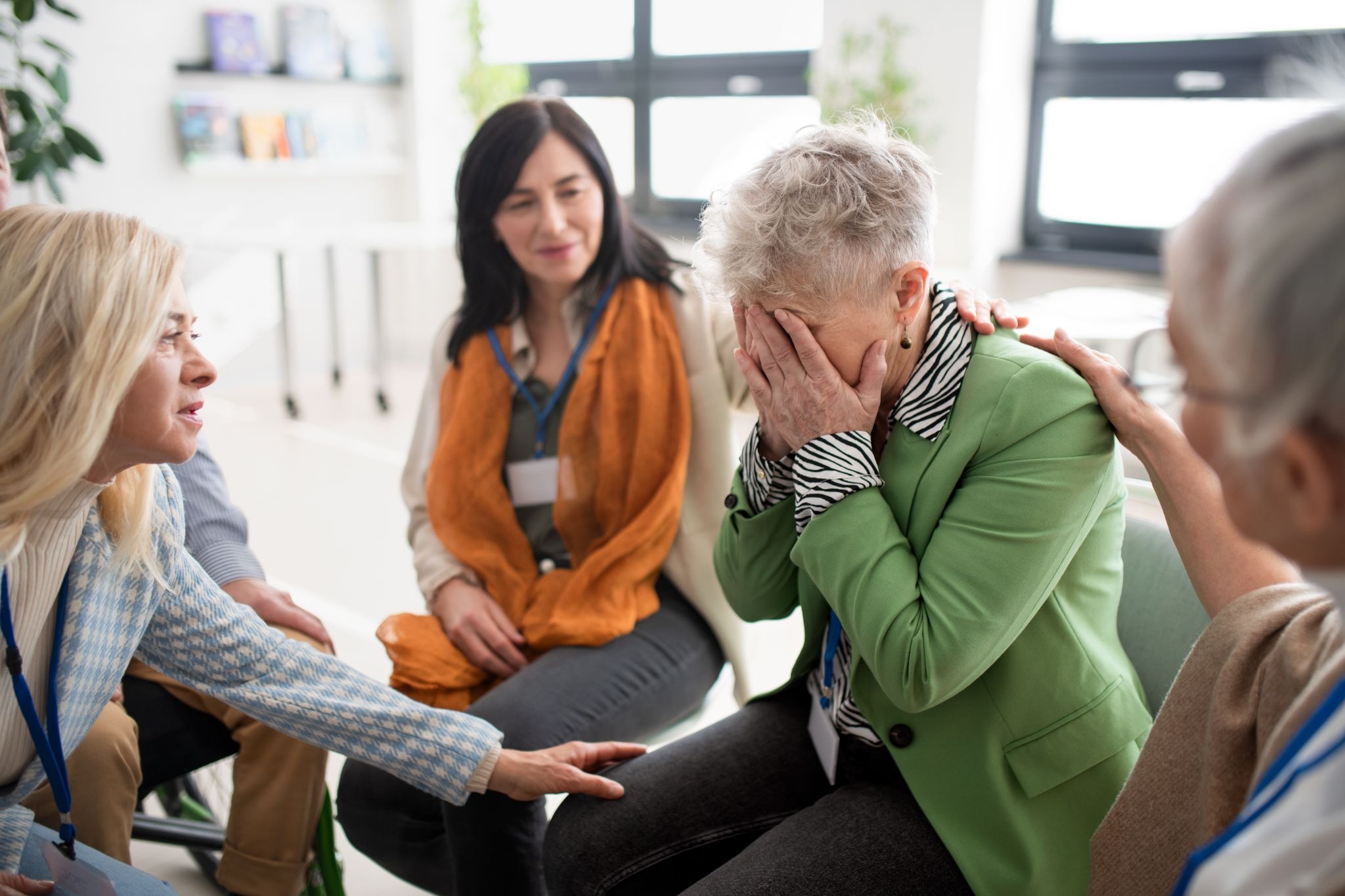 Support group helping a distressed woman experiencing workplace micro-trauma and emotional stress