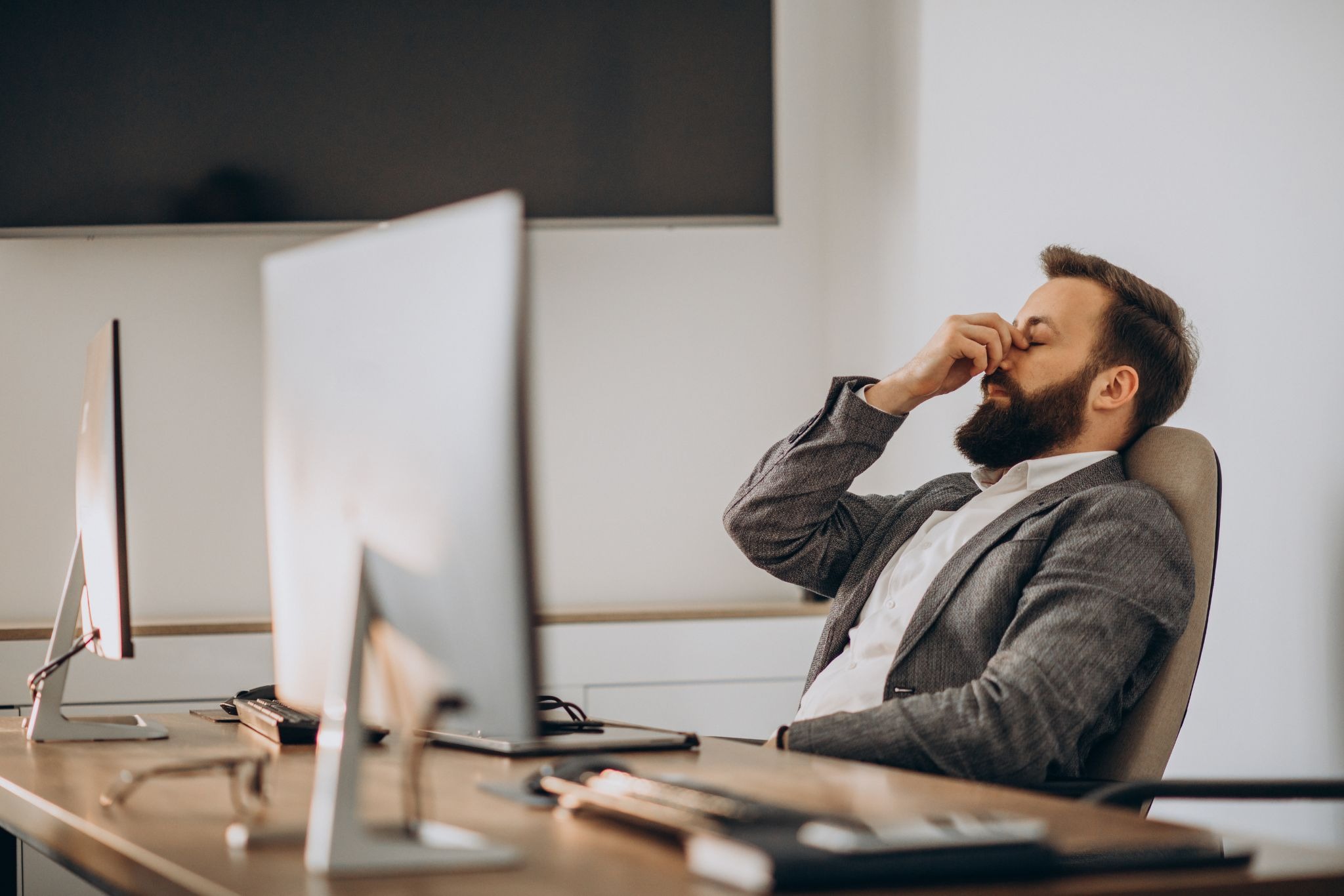 Exhausted office employee experiencing emotional exhaustion and workplace burnout at desk