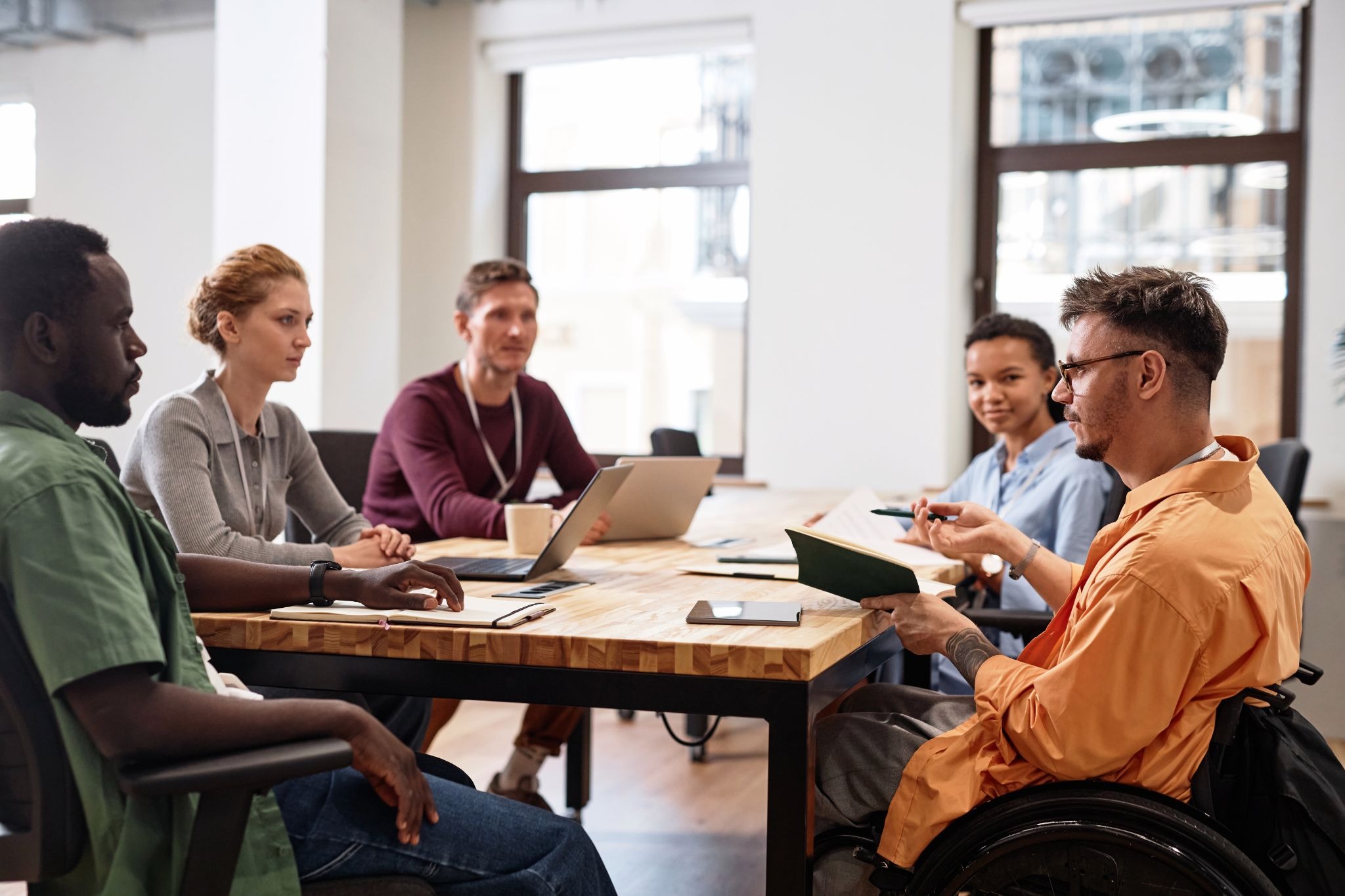 Diverse employees in a workplace meeting discussing workforce resilience and employee well-being analytics