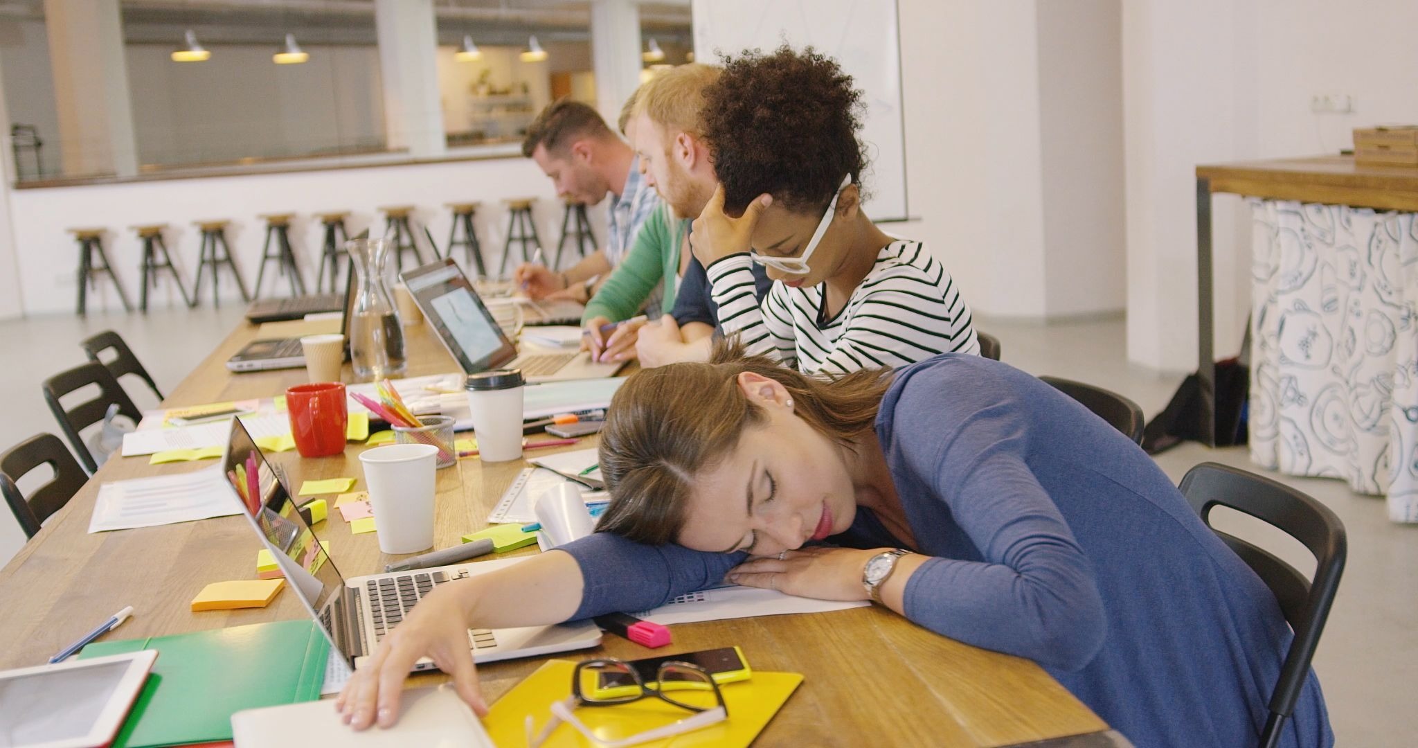 Employee experiencing presenteeism and burnout, asleep at desk during work hours