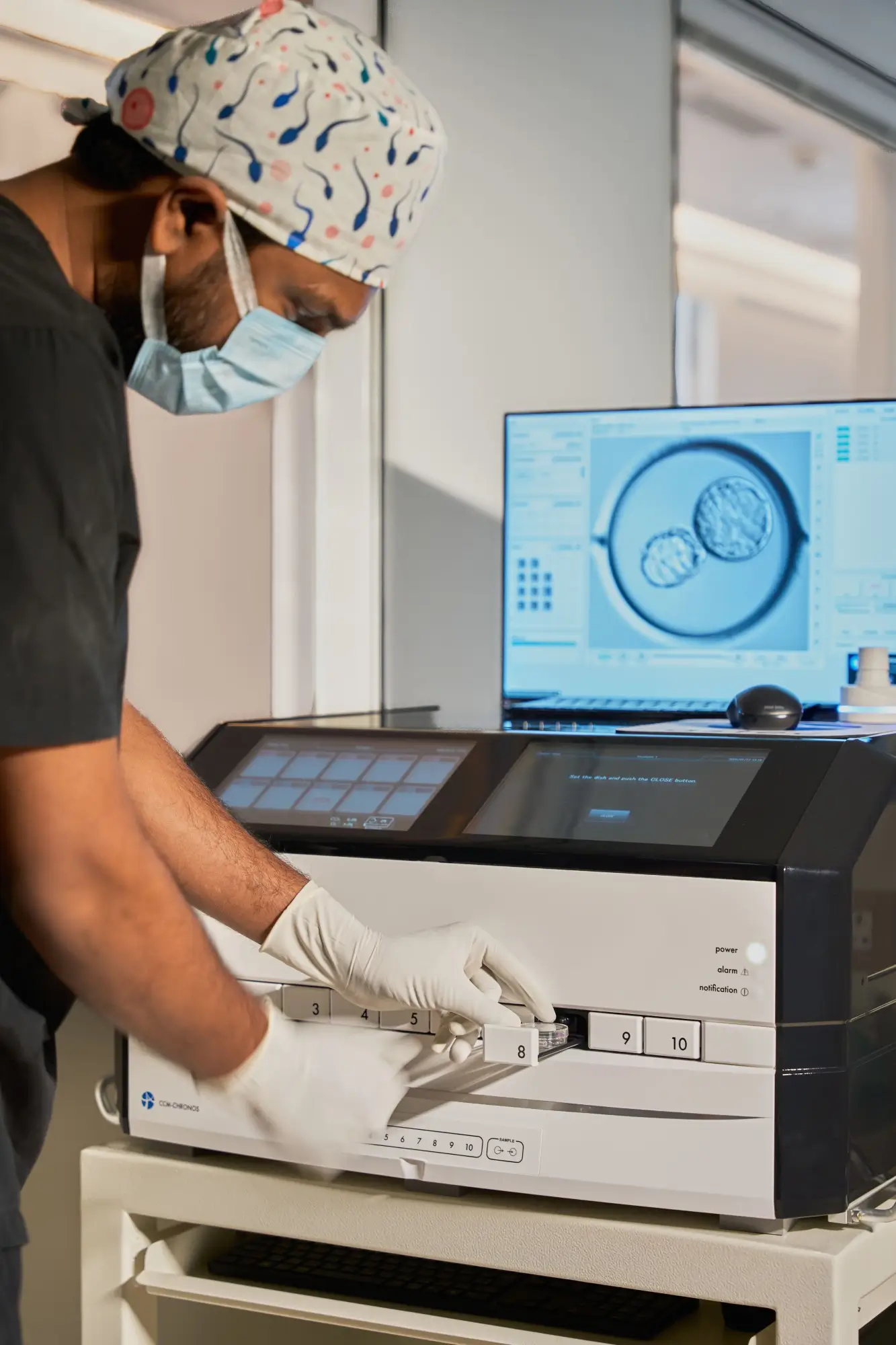 A man in a surgical mask operating a machine.