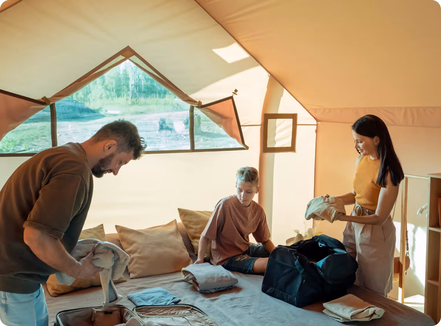 une famille défait ses valises dans leur chambre d'hôtel
