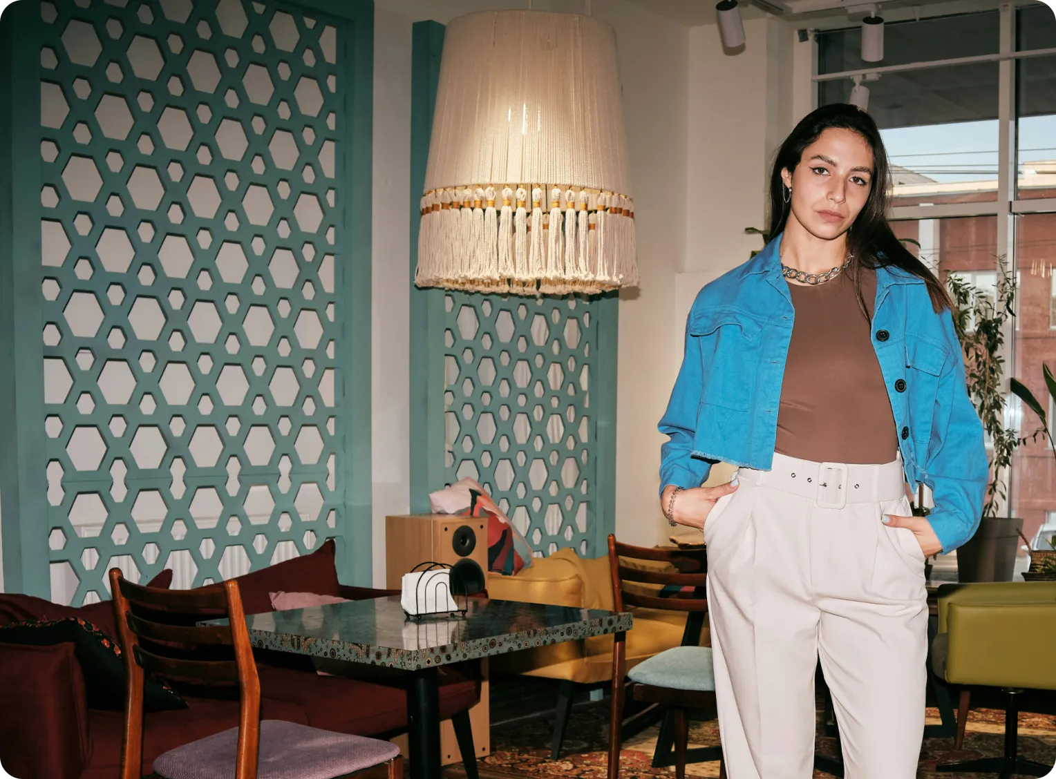 une jeunne femme se tient debout dans son salon