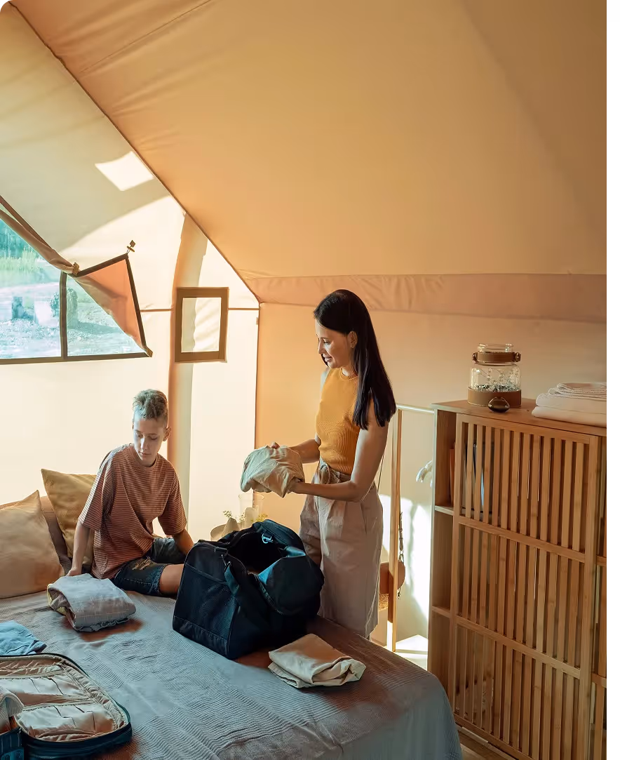 une famille défait ses valises dans leur chambre d'hôtel