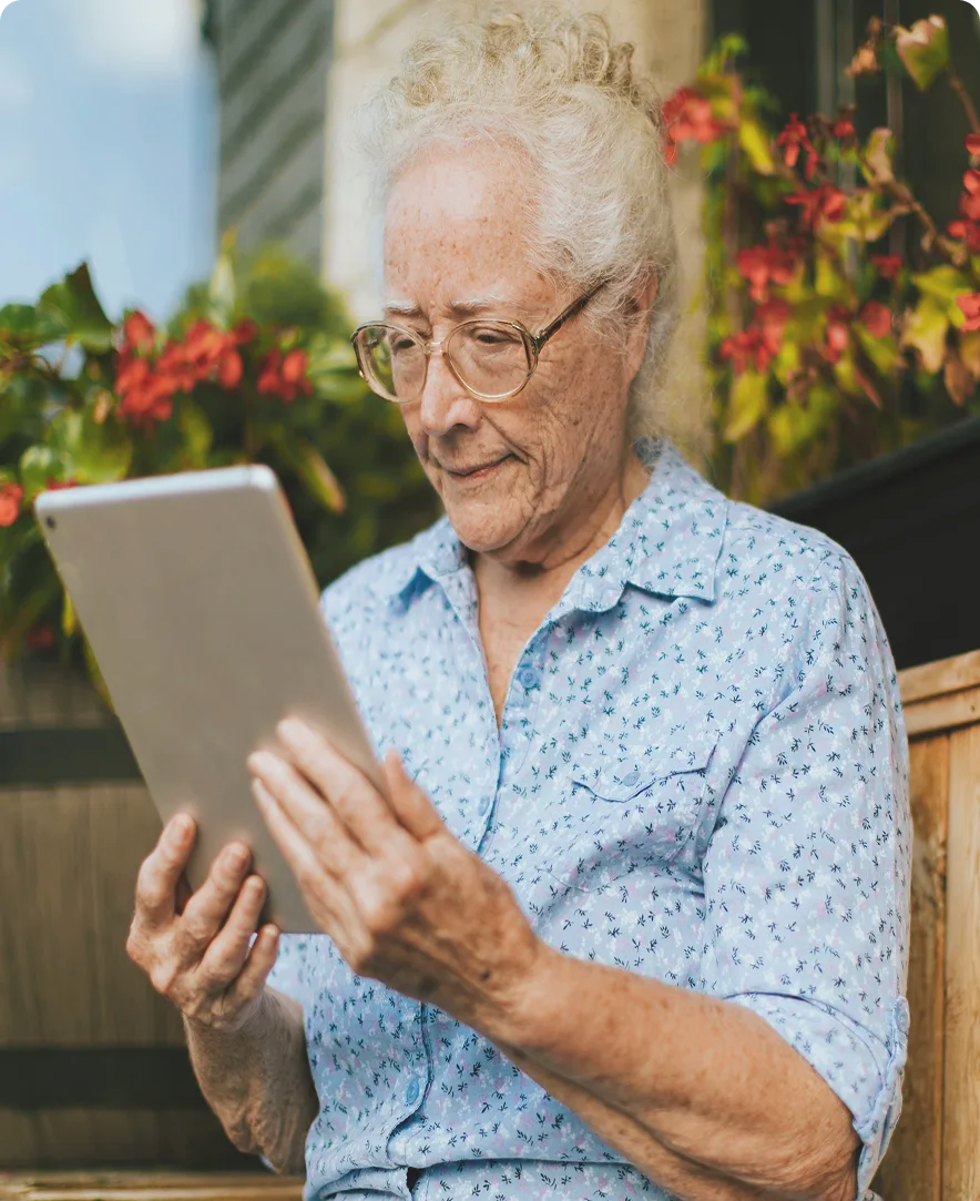 une femme agée utilise une tablette tactile