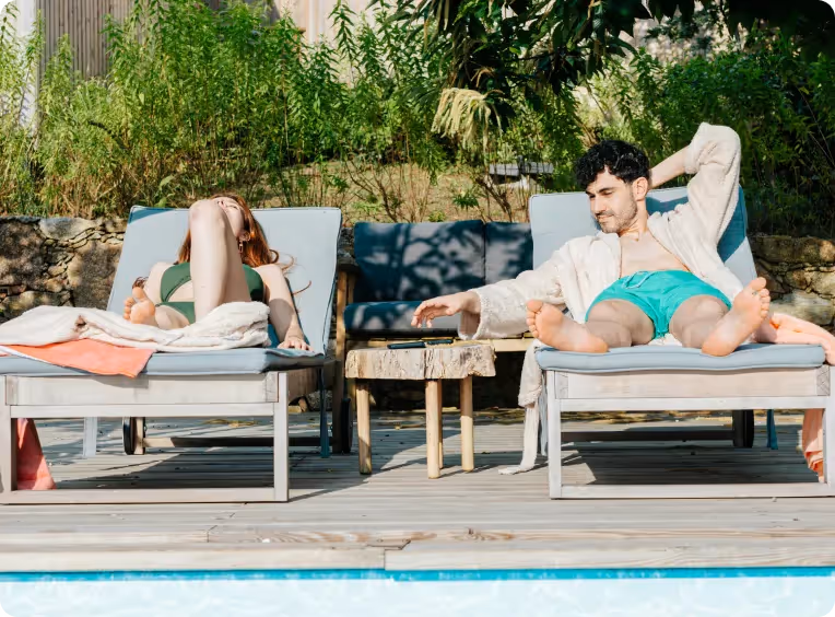une homme et une femme prennent le soleil au bord d'une piscine